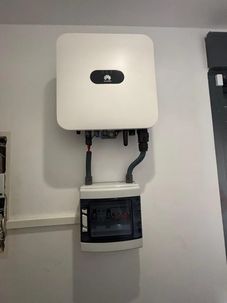 Inversor solar Huawei instalado en una pared junto a un cuadro de protecciones