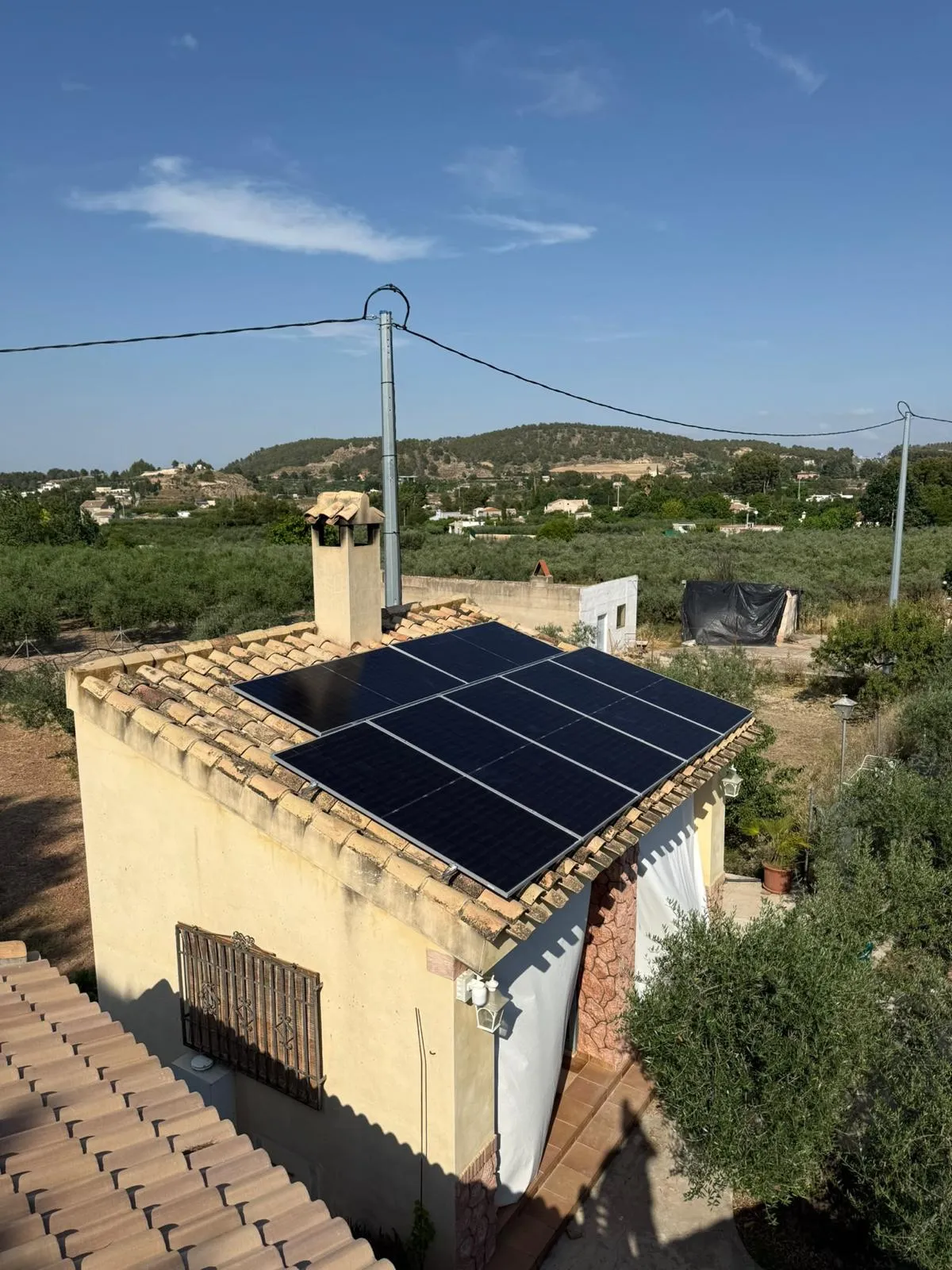 Paneles solares instalados sobre el tejado de teja de una vivienda en un entorno rural